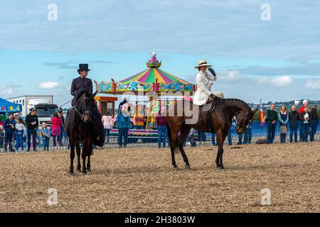 Two women in period costume doing a side-saddle horse-riding display at a horse event, UK Stock Photo