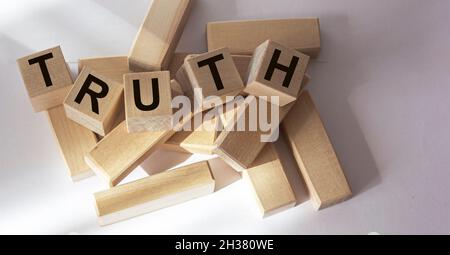 Truth - word from wooden blocks with letters, real facts truth concept, random letters around, white background Stock Photo