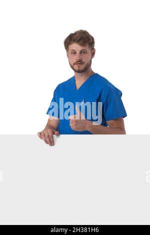 Healthcare, profession and medicine concept - happy smiling male doctor or nurse in blue uniform with big board showing thumbs up isolated over white Stock Photo
