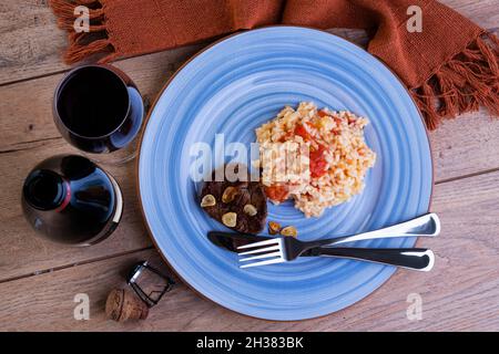 Tomato risotto with leek and Sicilian lemon and a bottle and a glass of sparkle wine - top view Stock Photo