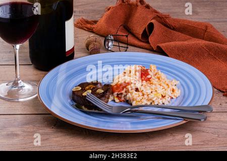 Tomato risotto with leek and Sicilian lemon and a bottle and a glass of sparkle wine Stock Photo