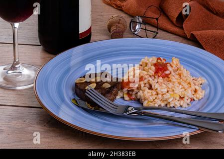 Tomato risotto with leek and Sicilian lemon and a bottle and a glass of sparkle wine Stock Photo