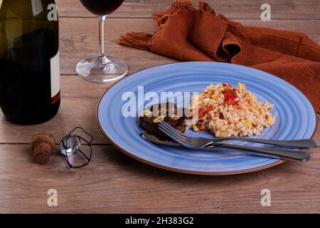 Tomato risotto with leek and Sicilian lemon and a bottle and a glass of sparkle wine Stock Photo