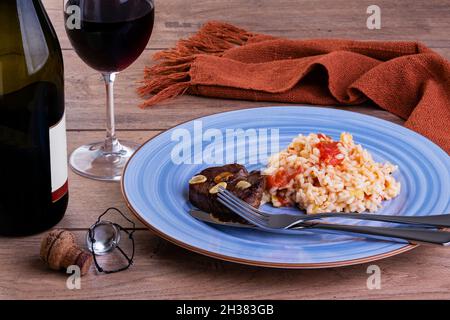 Tomato risotto with leek and Sicilian lemon and a bottle and a glass of sparkle wine Stock Photo