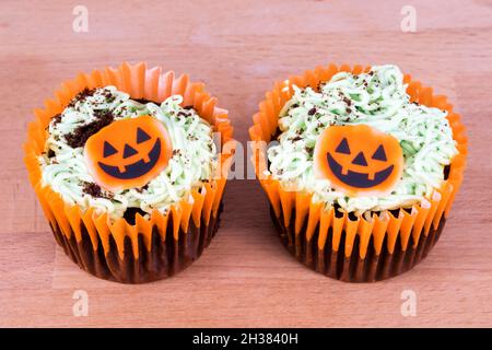 Two Sainsbury's pumpkin patch decorated chocolate cupcakes for Halloween. Stock Photo