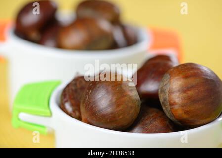 portuguese nuts in ceramic container on table with yellow jute Stock Photo