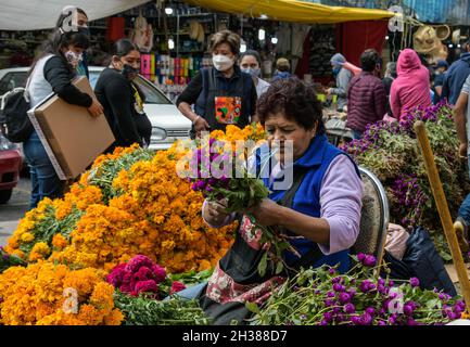 Non Exclusive: MEXICO CITY, MEXICO - OCTOBER 26, 2021: Persons buying cempasuchil flower and velvet flower, in the Jamaica outdoor market, traditional Stock Photo