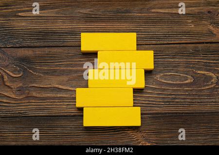 Yellow blocks on wooden background Stock Photo
