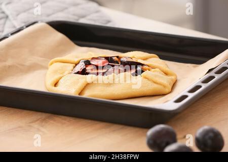 Baking tray with uncooked plum galette on table, closeup Stock Photo