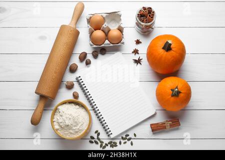 Ingredients for preparing pumpkin pie and notebook on light wooden background Stock Photo