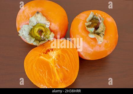 Slices of persimmon.Ripe orange persimmon fruit.fresh persimmon on rustic wooden table