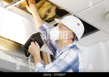 a man is working on home insulation work Stock Photo