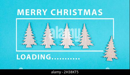 Wooden christmas trees on a blue colored background, loading bar, xmas icon Stock Photo