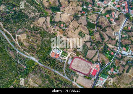 Aerial drone view over country stadium in Velventos village close to Polyfytos artificial lake. Larissa, Greece. Stock Photo