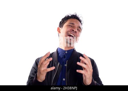 Man with evil laugh isolated on white background. Young latin adult young man expressing evil with his hands and laughter. Expression of happy villain Stock Photo