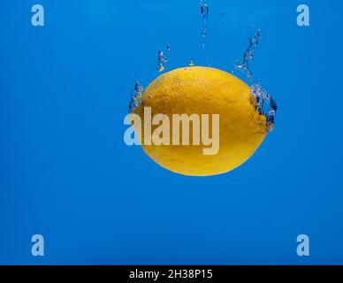 lemon with water bubbles on a blue background Stock Photo