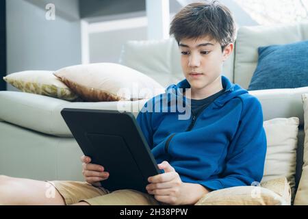 The boy using tablet at home. Stock Photo