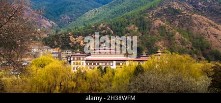 Traditional building in the capital of Bhutan Thimphu against the backdrop of the foothills of the Himalayas in the spring Stock Photo