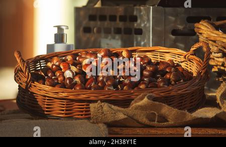 A wicker basket with a pile of edible chestnuts at a farmer's street market.