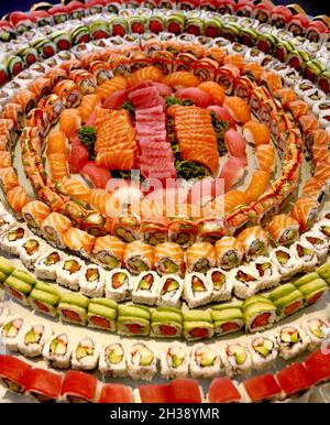 Large platter of fresh sushi and sashimi at event or celebration.  Combination of rolls.  Tuna, salmon, crab, avocado, with white sushi rice. Stock Photo
