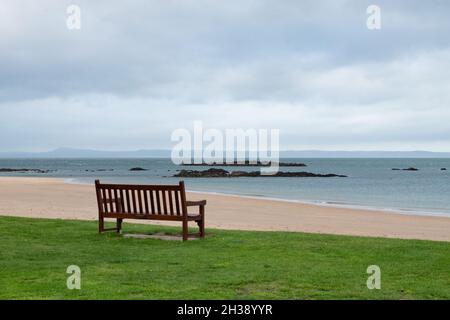 empty wooden bench facing out to sea, North Berwick, Scotland, UK Stock Photo