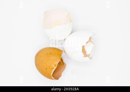 White and brown broken egg shells, cracked egg shells, isolated on white background Stock Photo