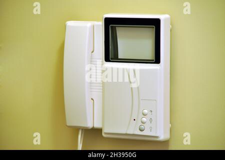 Modern video intercom hanging on the wall at the entrance of the apartment building or house Stock Photo