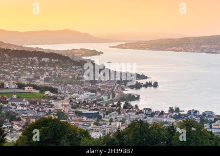 View at sunset from Feusisberg across Lake Zurich to Zurich, with Wollerau, Richterswil, Waedenswil and Meilen and the Uetliberg in the background Stock Photo