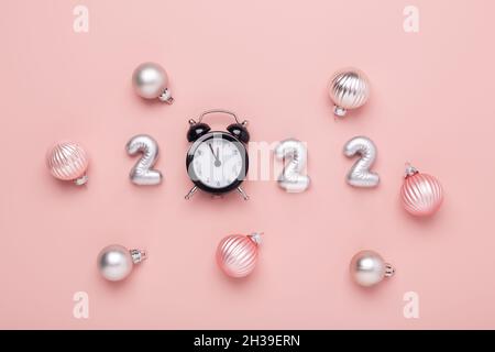 Silver numbers 2022 and black alarm clock on pink background. New year celebration - Image Stock Photo