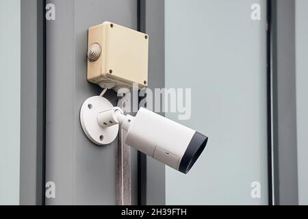 A video surveillance camera hangs on a metal profile Stock Photo