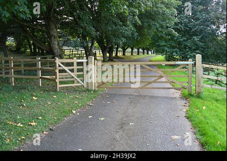 A five bar gate with a kissing gate for pedestrians at the side lies across a footpath in the north Oxfordshire village of Hook Norton Stock Photo