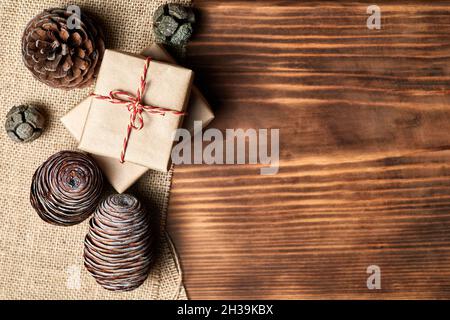 Christmas Flatlay of pine cones and gift boxes on wooden background with copy space Stock Photo