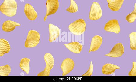 Wavy potato chips flying in the air on purple background Stock Photo
