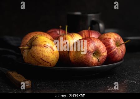 Fresh autumn apples on plate on black table. Stock Photo