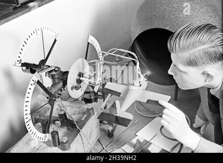 Ein Flugschüler schaut sich anhand eines Modells die Steuerung eines Flugzeuges an, Deutschland 1930er Jahre. A pilot trainee studying the steering of a plane by observing a model, Germany 1930s. Stock Photo