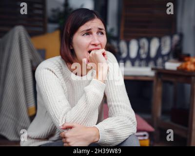 Young depressed asian woman sitting on porch of backyard. She feeling sad and worried suffering depression in mental health. Mental health, anxiety de Stock Photo