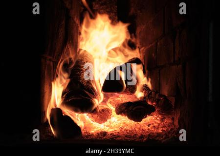 A Fire Is Burning In A Brick Village Stove. Flames, Hot Coals and Logs. Stock Photo