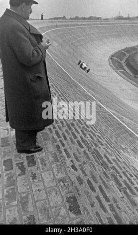 Der deutsche Ingenieur Ferdinand Porsche stoppt die Zeit eines Mercedes Benz Silberpfeil auf der AVUS Rennstrecke in Berlin, Deutschland 1930er Jahre. German engineer and inventor Ferdinand Porsche takin the time for a lap of a Mercedes Benz Silver Arrow at  Berlin AVUS race track, Germany 1930s. Stock Photo