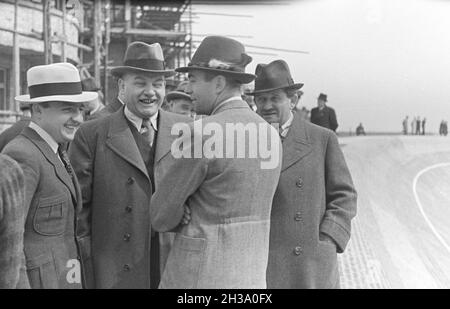 Der deutsche Ingenieur Ferdinand Porsche (rechts) im Gespräch mit Kollegen an der AVUS Rennstrecke in Berlin, Deutschland 1930er Jahre. German engineer and inventor Ferdinand Porsche (right) talking to colleagues at Berlin AVUS race track, Germany 1930s. Stock Photo