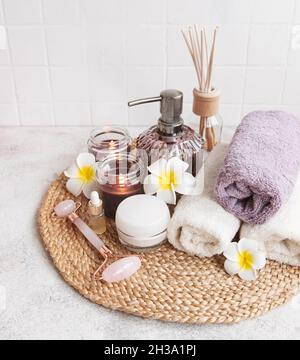 Spa set, essential oil, massage salt, candle and  frangipani flowers on gray concrete background Stock Photo