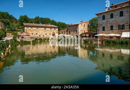 Bagno Vignoni, Tuscany, Italy. August 2020. A large natural outdoor thermal hot water pool is point of interest for tourists. Stock Photo