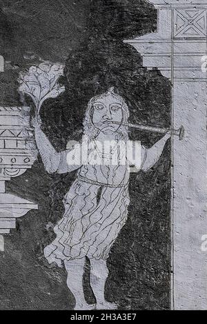 A woman or girl in a knee-length dress holds a spray of flowers aloft while blowing a horn in this charming detail of rustic sgraffito art beside an inscription dated 1664 on the facade of a traditional Engadiner house at Ardez in the Lower Engadine Valley, Graubünden or Grisons canton, eastern Switzerland. Stock Photo