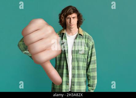 Annoyed caucasian guy hipster showing thumb down Stock Photo