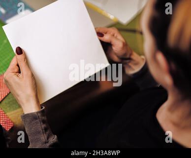 blank white paper sheet in female hands close-up. template for your text and design Stock Photo