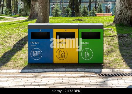 Recycle trash bins with garbage icons on the street. Stock Photo