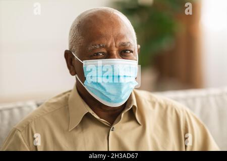 Sick Senior African American Man Wearing Protective Face Mask Indoors Stock Photo