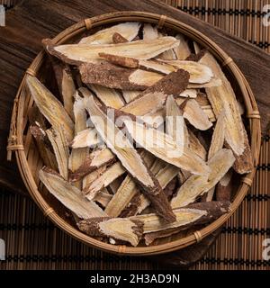 Top view of Chinese traditional herbal medicine Astragalus root on wooden table background. Stock Photo