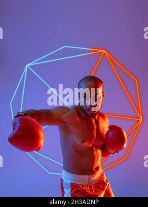 Creative artwork of prfessional male boxer in motion over neon geometric element isolated over purple background Stock Photo