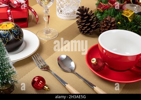 Christmas dinner table decorations with a red ceramic coffee cup. Stock Photo