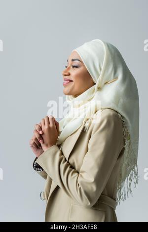 Portrait of happy muslim woman in hijab posing isolated on grey Stock Photo